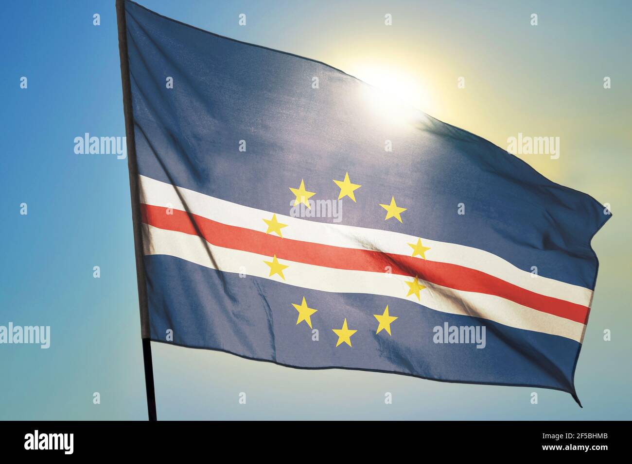 Cabo Verde flag waving on the wind in front of sun Stock Photo