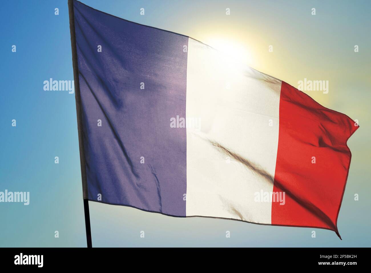 France flag waving on the wind in front of sun Stock Photo