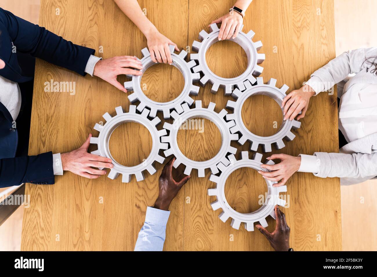 Businesspeople Hands Joining Gears. Support And Implementation Stock Photo
