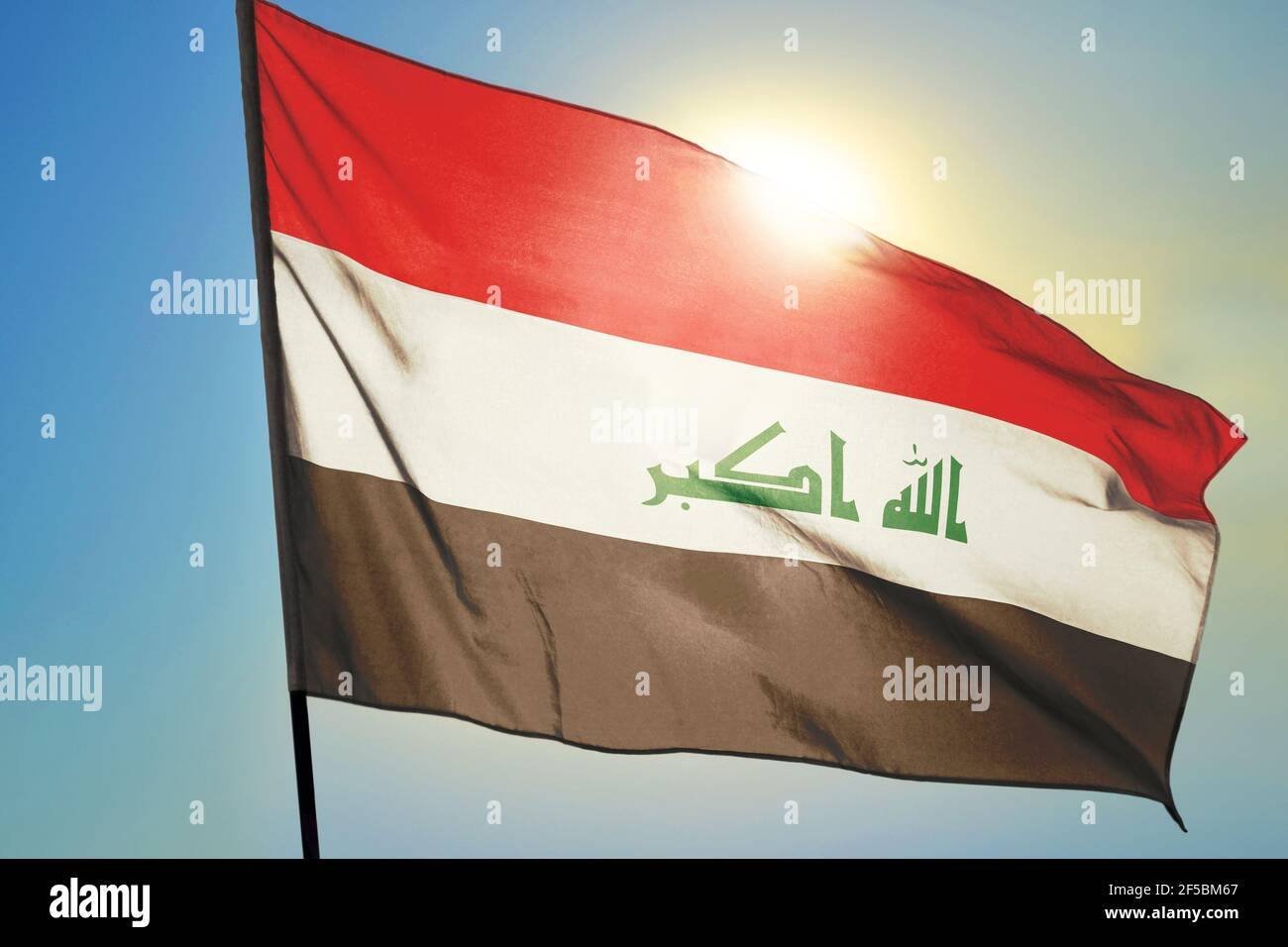 Iraq flag waving on the wind in front of sun Stock Photo