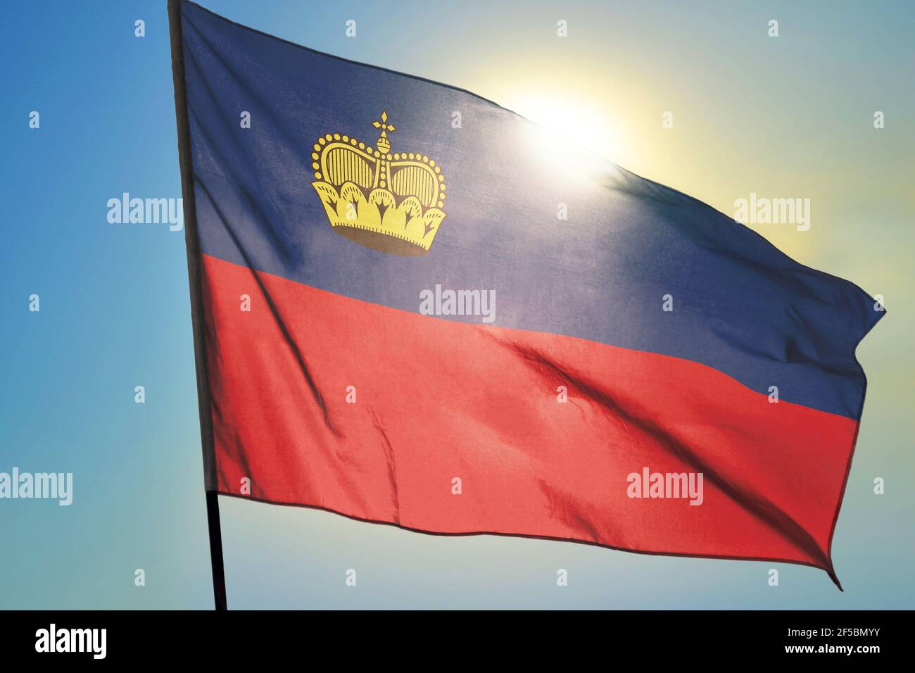 Liechtenstein flag waving on the wind in front of sun Stock Photo