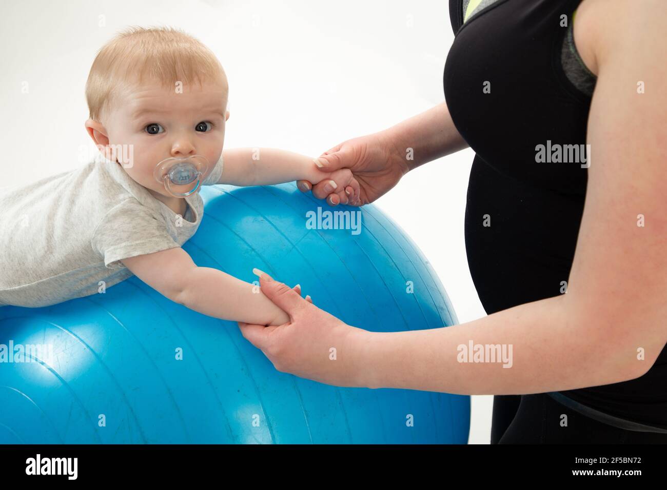 mother holding 5 month old baby balancing on yoga Stock Photo Alamy