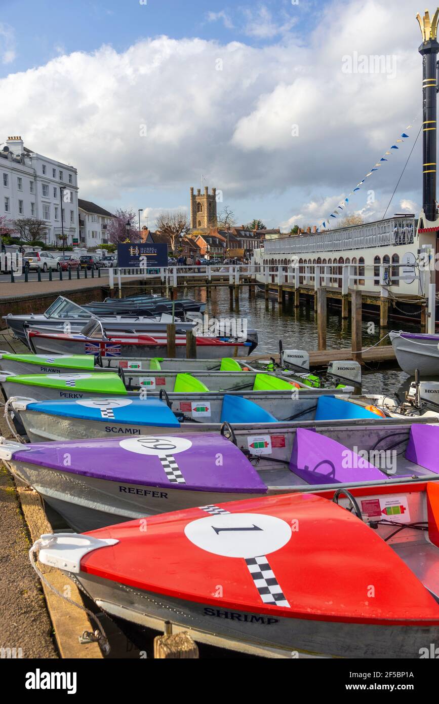 Colourful boats for hire beside the River Thames  with St Mary's Church in the background, Henley-on-Thames, Oxfordshire, England, UK Stock Photo