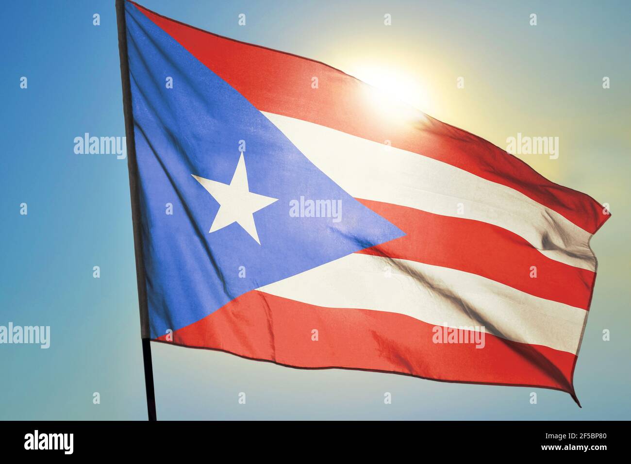 Puerto Rico flag waving on the wind in front of sun Stock Photo