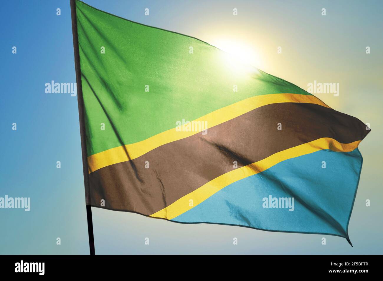 Tanzania flag waving on the wind in front of sun Stock Photo - Alamy