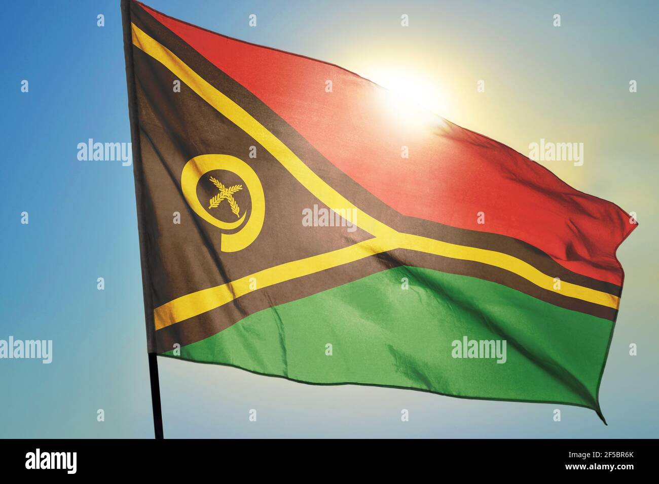 Vanuatu flag waving on the wind in front of sun Stock Photo