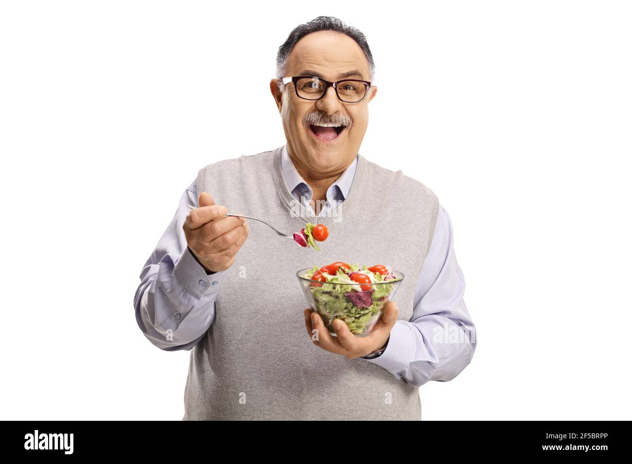 Happy mature man standing and eating a salad isolated on white background Stock Photo