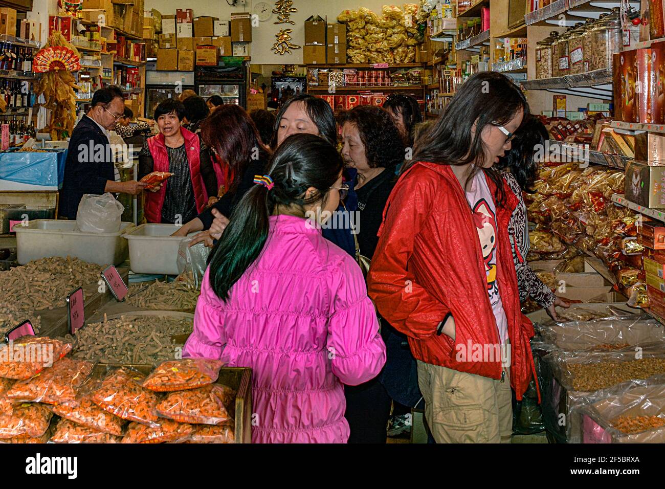 A crowded store with Asian shoppers looking over Chinese foodstuffs packaged and displayed in market in Chinatown area of Bangkok, Thailand Stock Photo