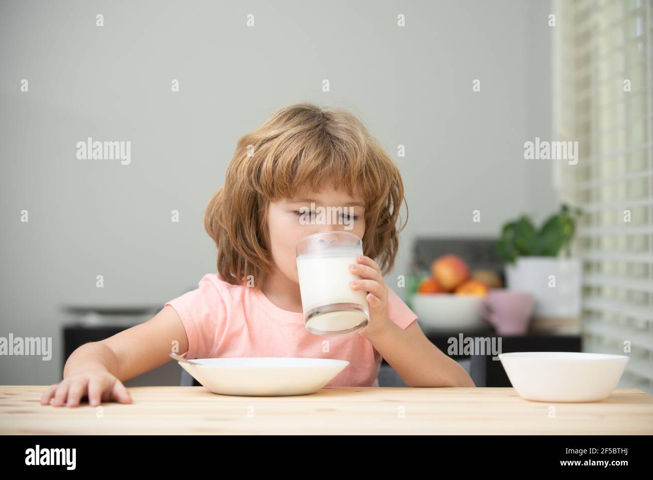 Organic milk with calcium. Little child drink milk. Kid eating healthy food. Stock Photo