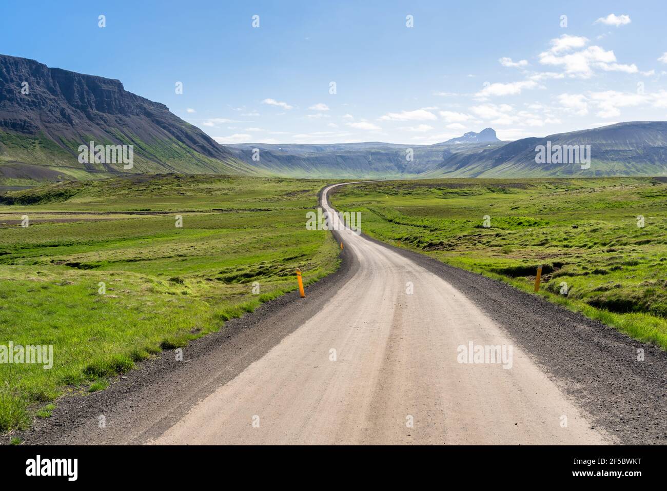 Windind unmade road running through a grassy valley on a clear summer day Stock Photo