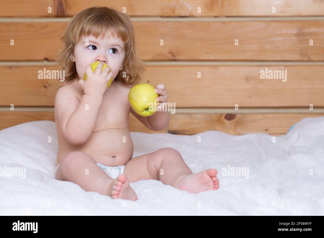 Cute baby eat apple. Kid eating fruit. Healthy nutrition for kids