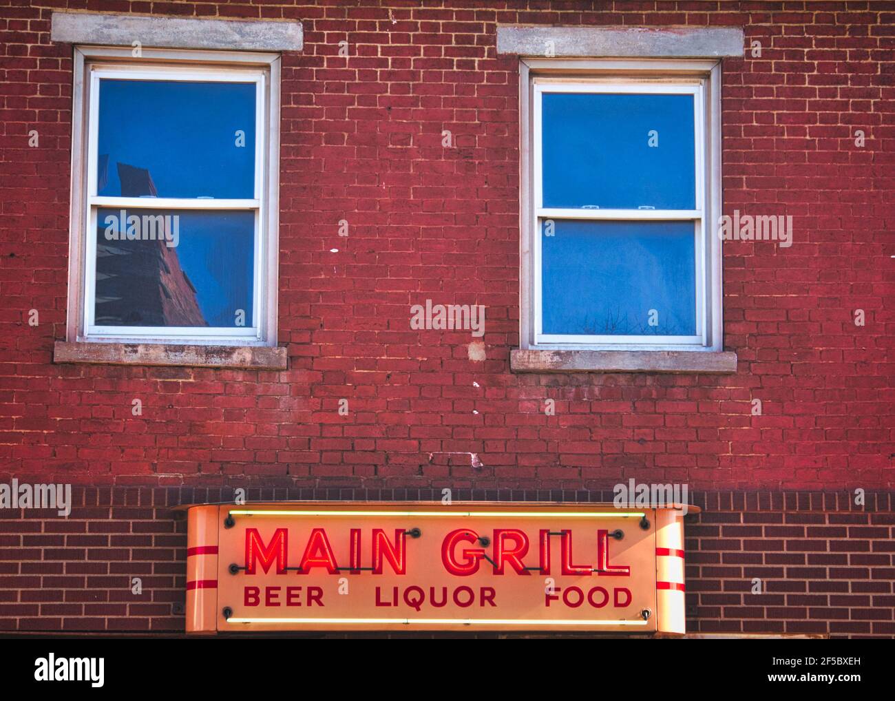Main Grill neon sing on brick building Stock Photo