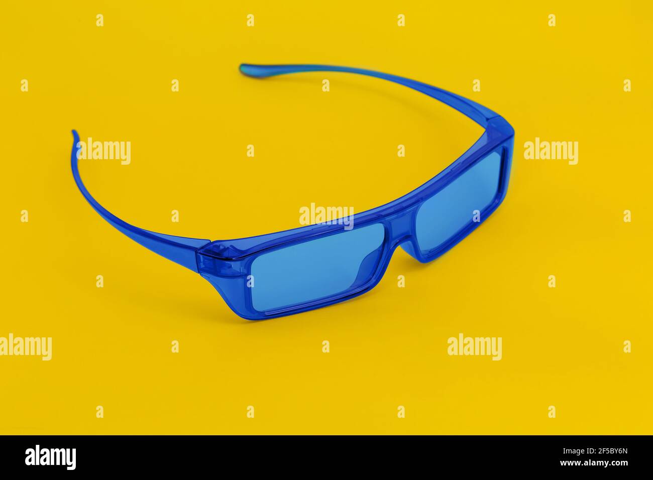Blue glasses on yellow background. Minimal contrast concept. Stock Photo