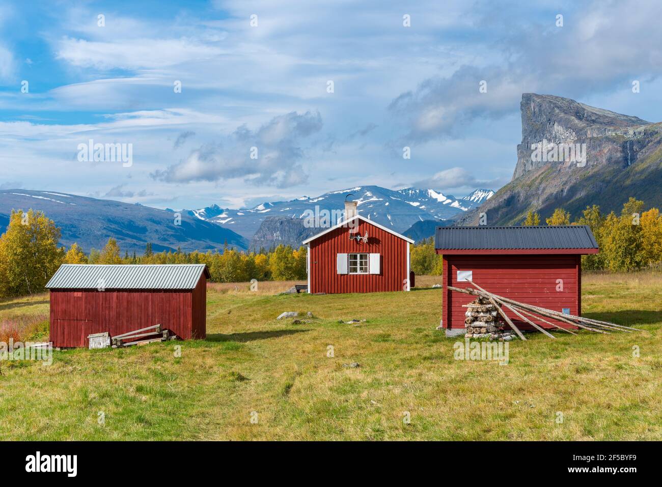 Red wooden house in arctic wilderness. Aktse mountain cabin deep in Sarek National Park, Sweden. Antlers on the wall. Sunny day of autumn in the Stock Photo