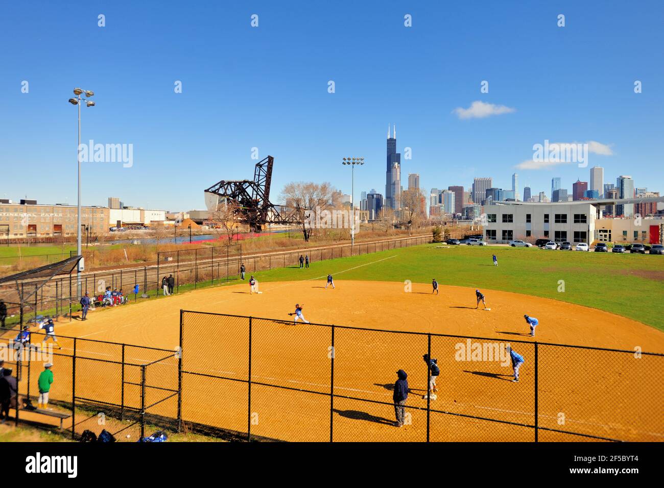 Chicago, Illinois, USA. A youth baseball game being played in the inner city not far from downtown Chicago and the city's famous Loop. Stock Photo