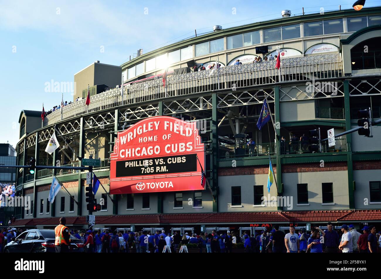 Chicago, Illinois, USA. Fans gather under the iconic marquee above the main entry to Wrigley Field on game night. Stock Photo
