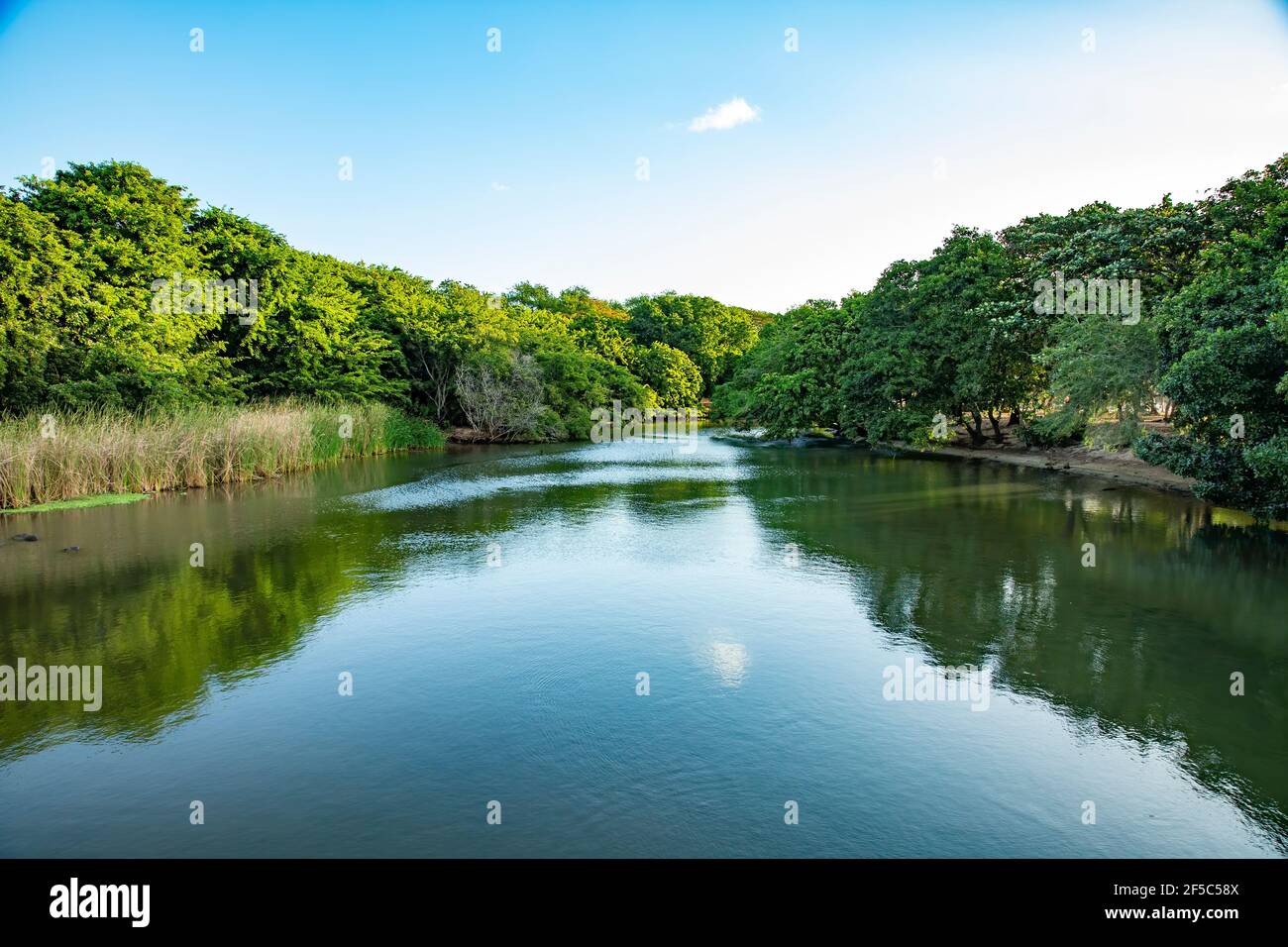 River near the public beach of Albion with blue cloudy sky in the background in the west of Mauritius. Stock Photo