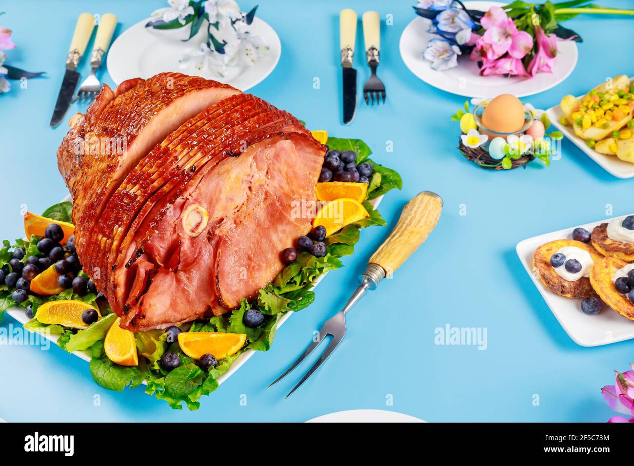 Pre sliced honey ham on party table for Easter. Stock Photo