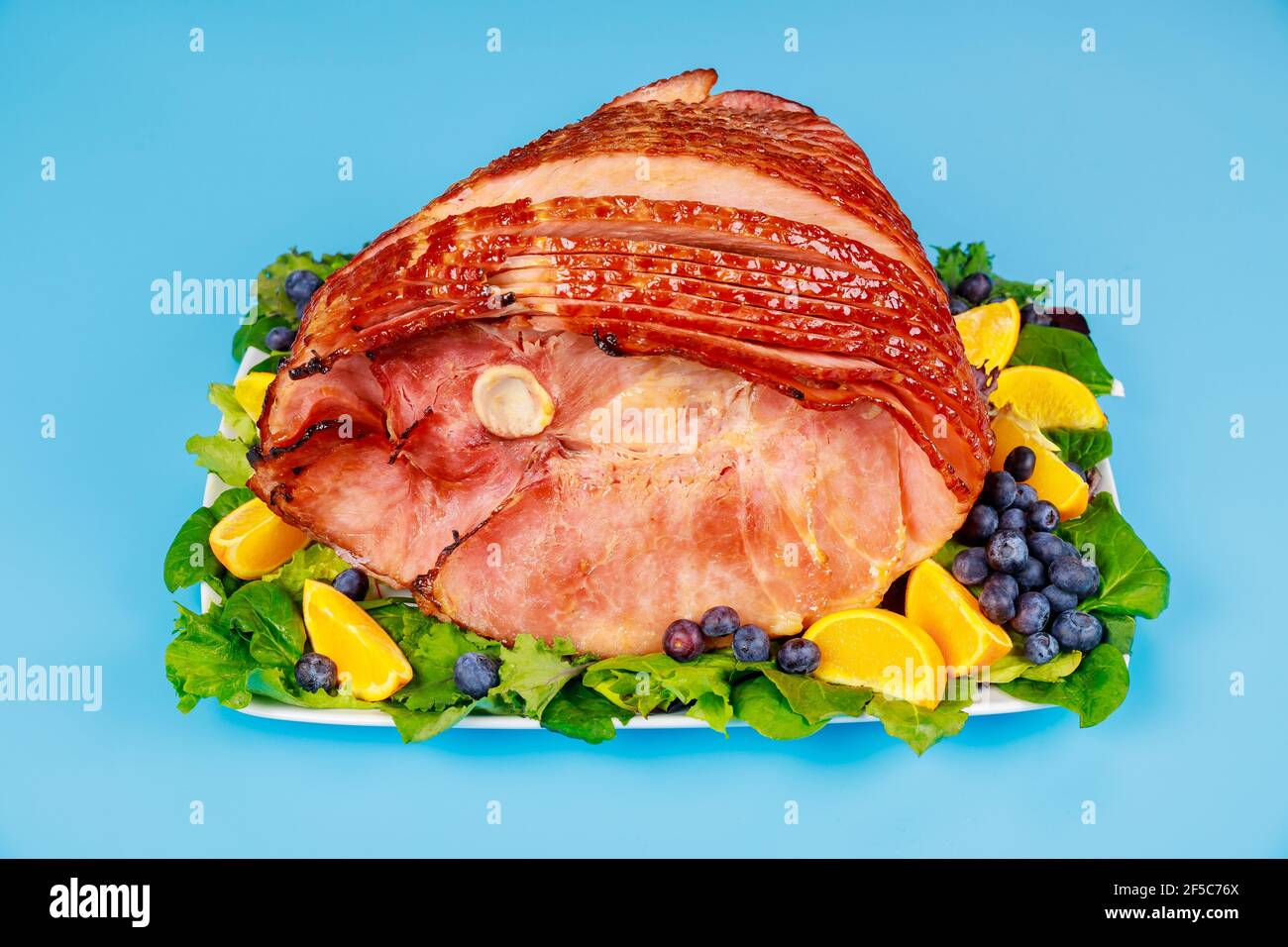 Whole pork ham with fresh fruits. Healthy food. Stock Photo