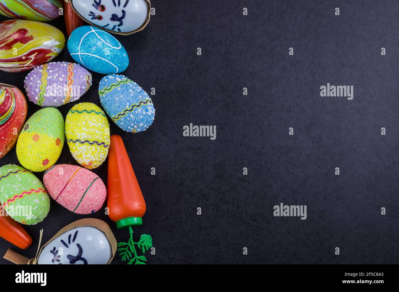 Colorful Easter eggs and other objects on a trendy black background for various Easter themed backgrounds Stock Photo