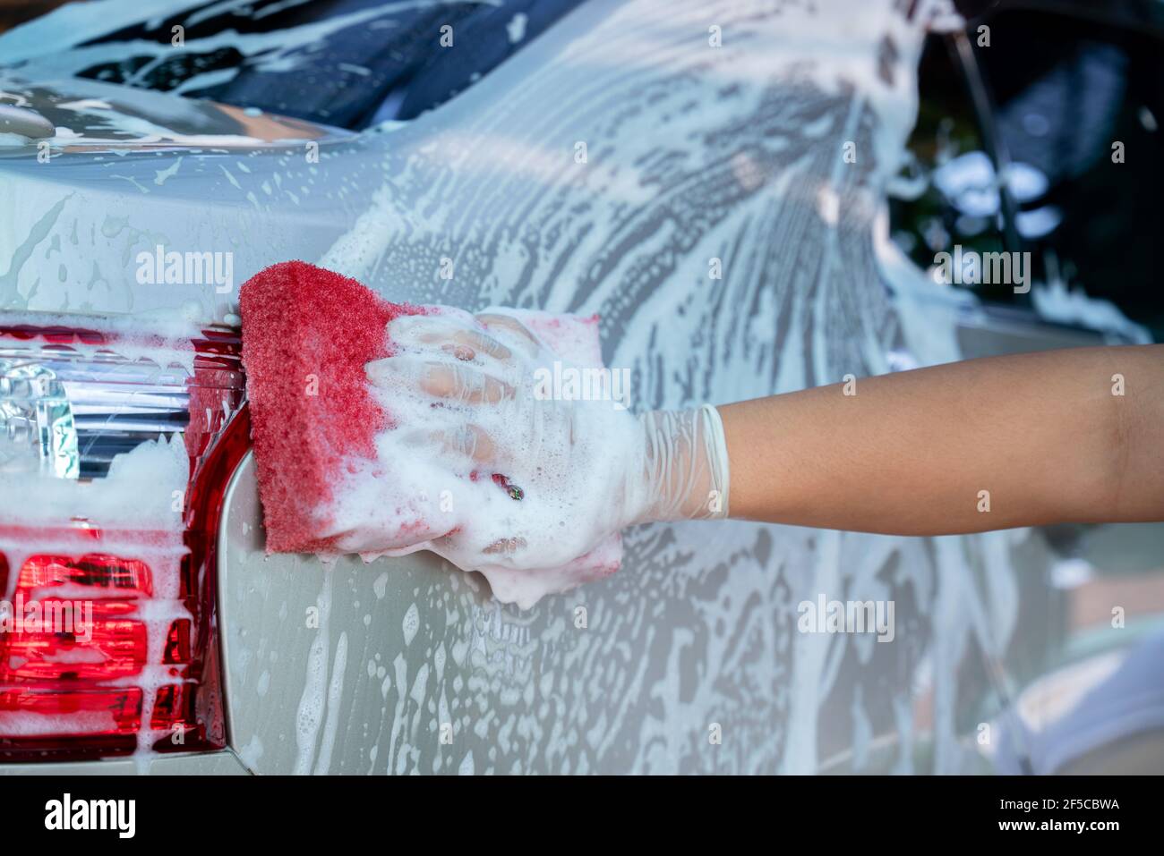 hand wear gloves of hold sponge over the car for washing, Car wash