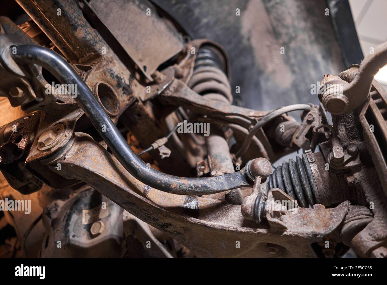 Inspects suspension, steering parts, tie rod ends. Car on a repair stand. Technical service station for car. Stock Photo