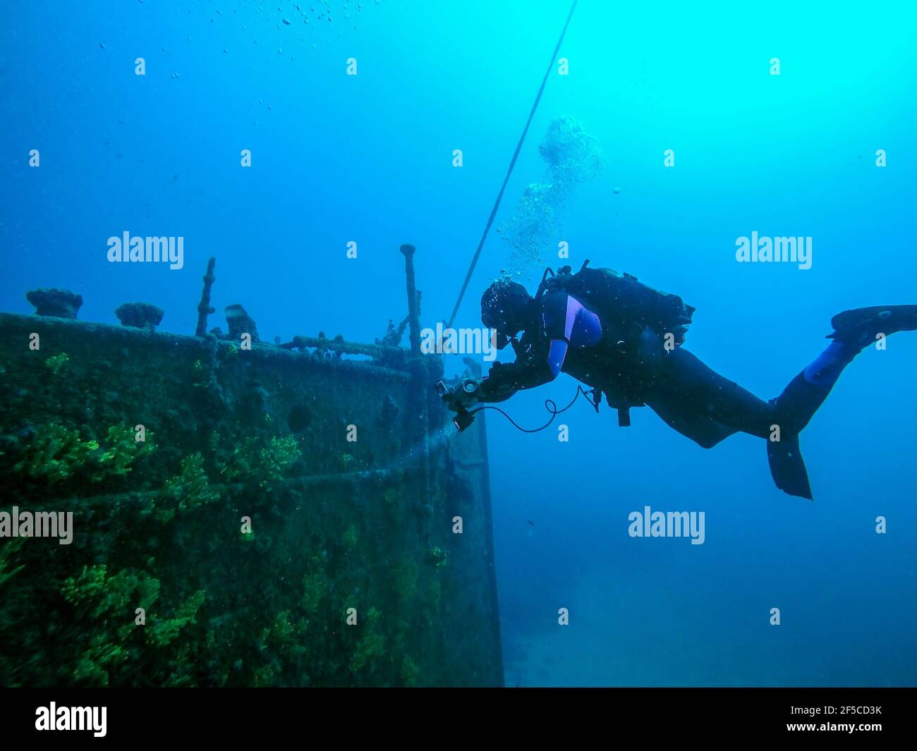 Old Sunken Ship on Ocean Seabed. Scuba Diving Explroing The Shipwreck. Stock Photo