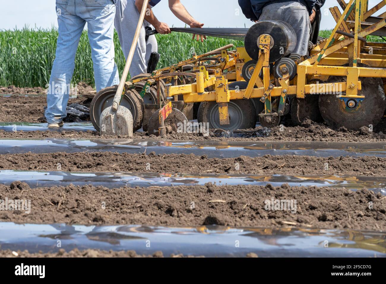 Tractor with agricultural equipment in the same pass dispenses