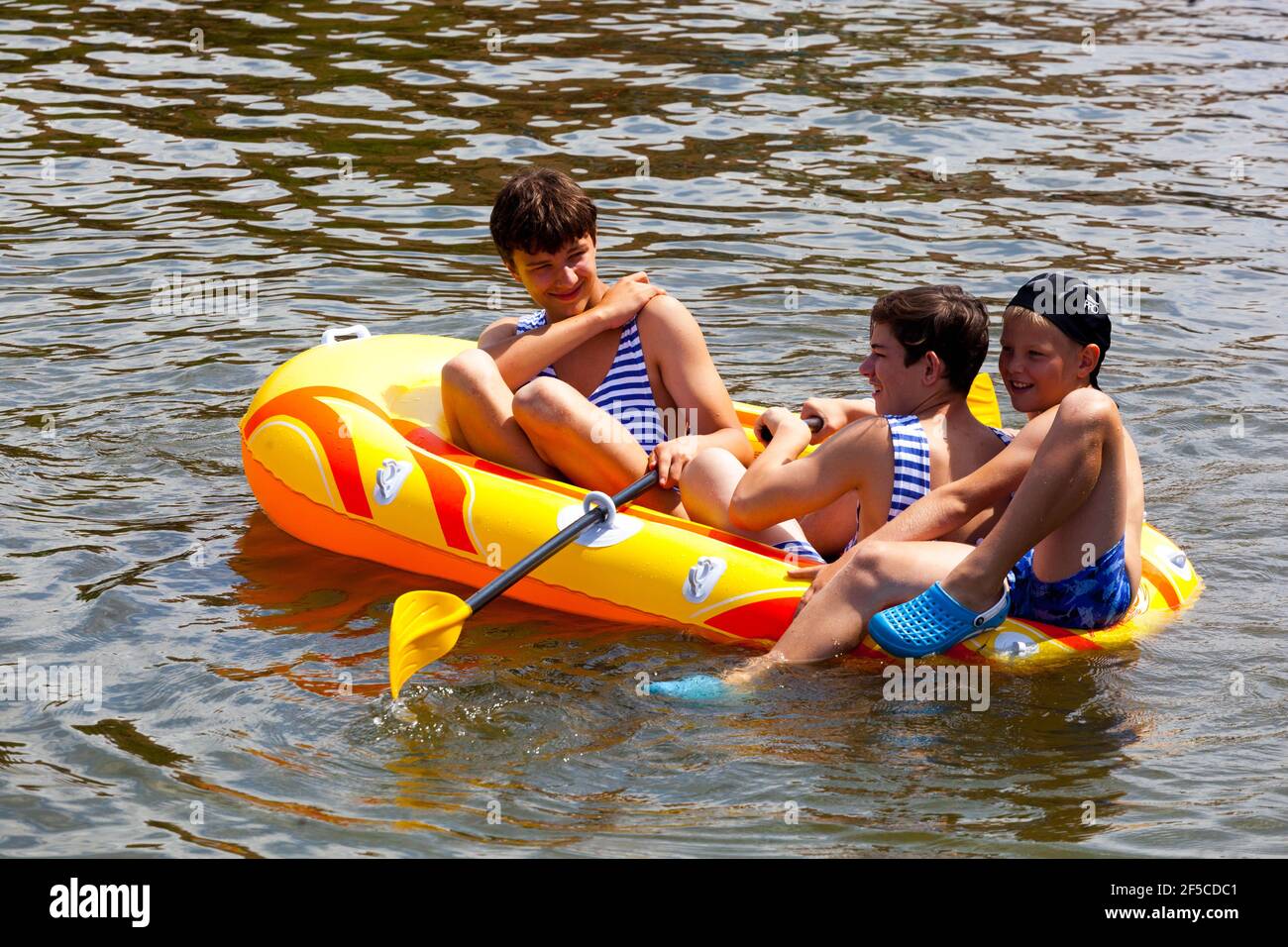 Three teenagers day summer, Boys in inflatable boat Stock Photo