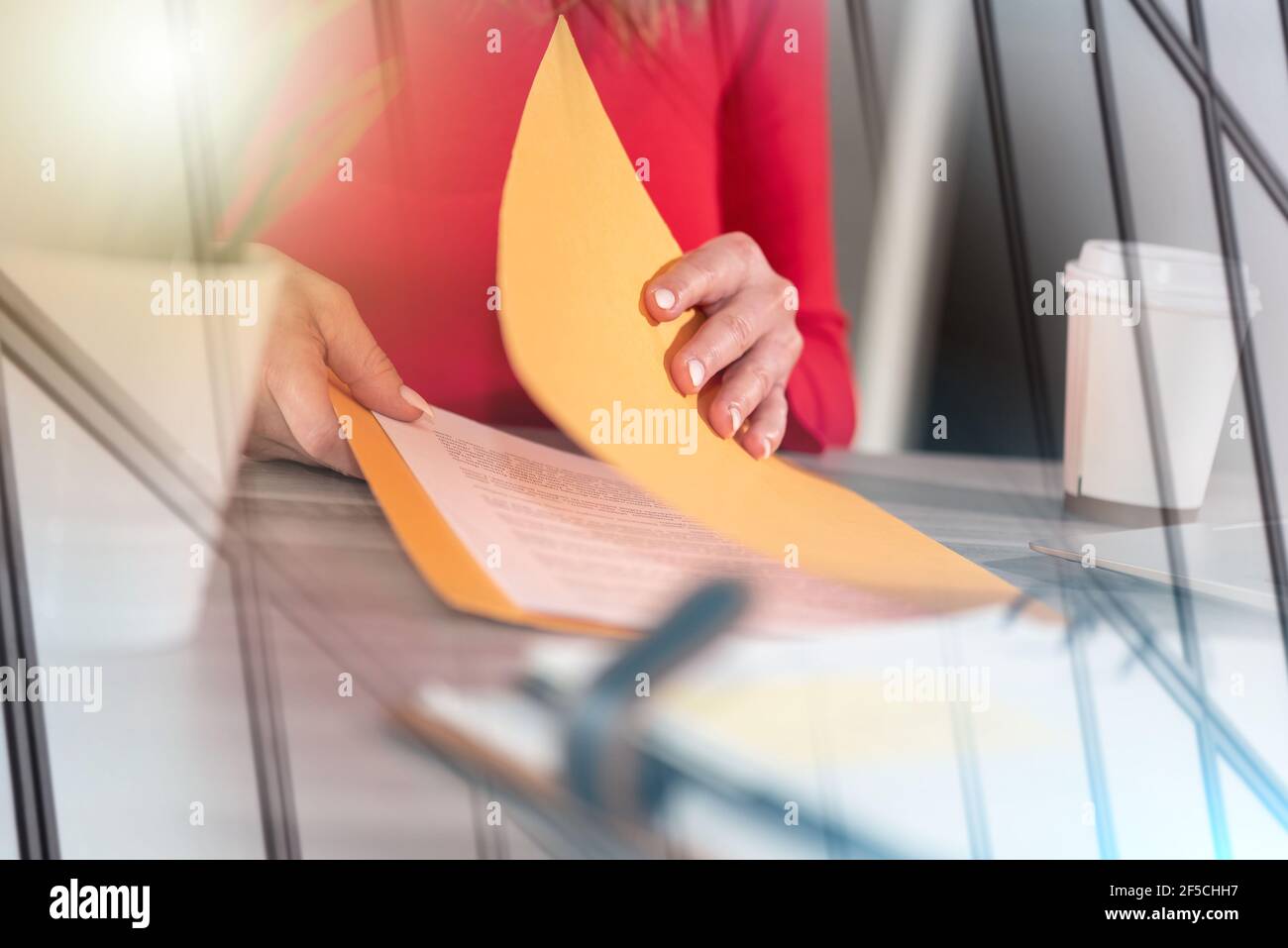 Businesswoman opening folder with paper documents; multiple exposure ...