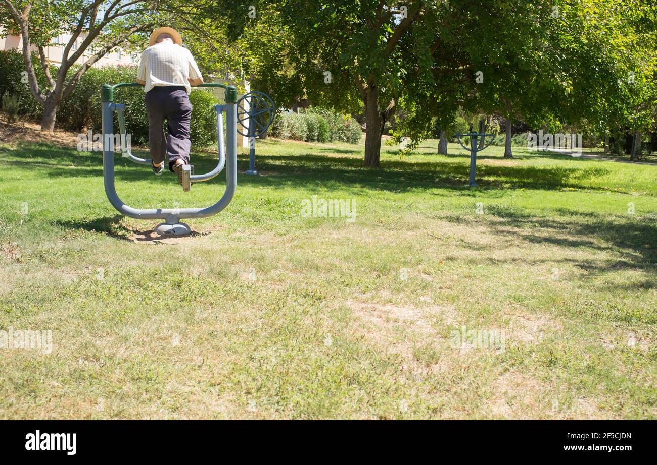 Elder man makes exercises at Outdoor Gym Park. Healthy active ageing concept Stock Photo