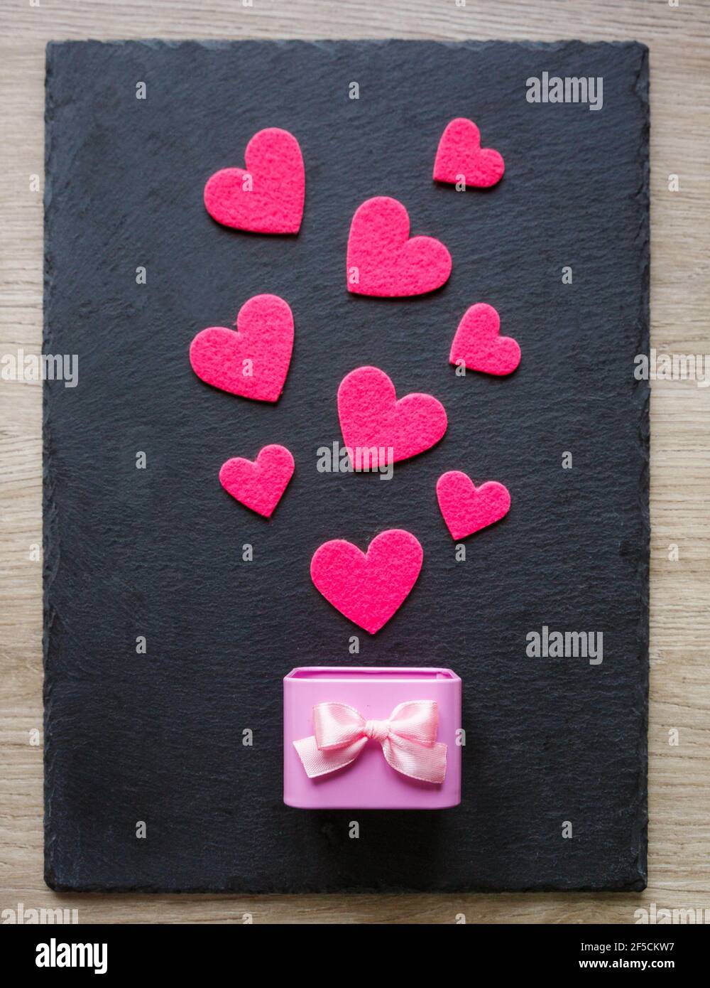 Pink felt hearts and delicate pink gift box on black background.  Valentine's Day gift or greeting card. Top view Stock Photo - Alamy