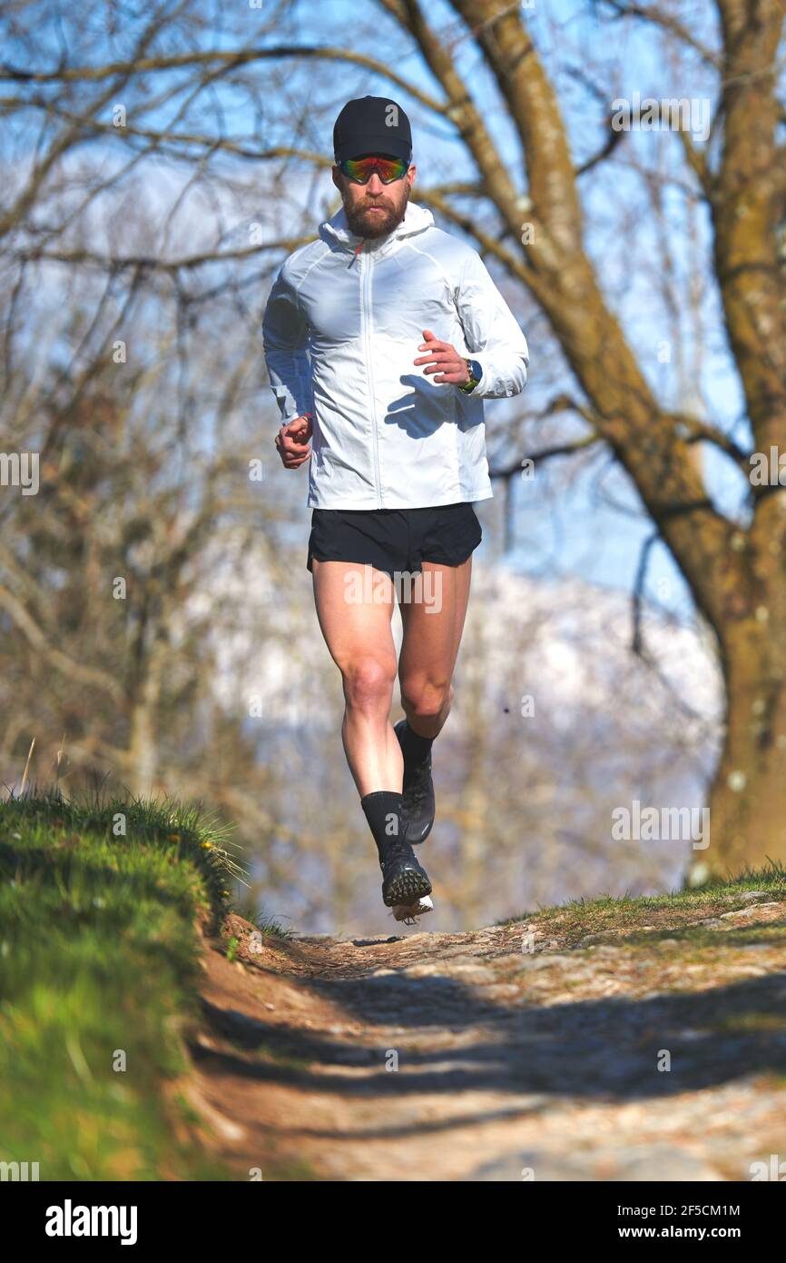 Young man running athlete during a workout in a hill Stock Photo