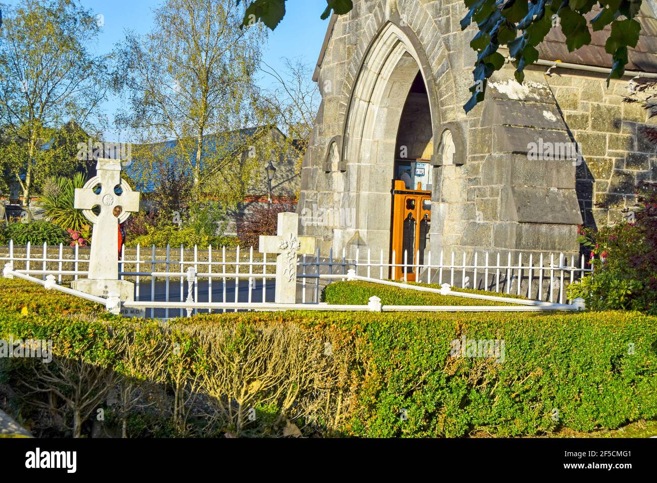 Holy Trinity Abbey church with celtic crosses in front, Adare, County Limerick, Ireland Stock Photo