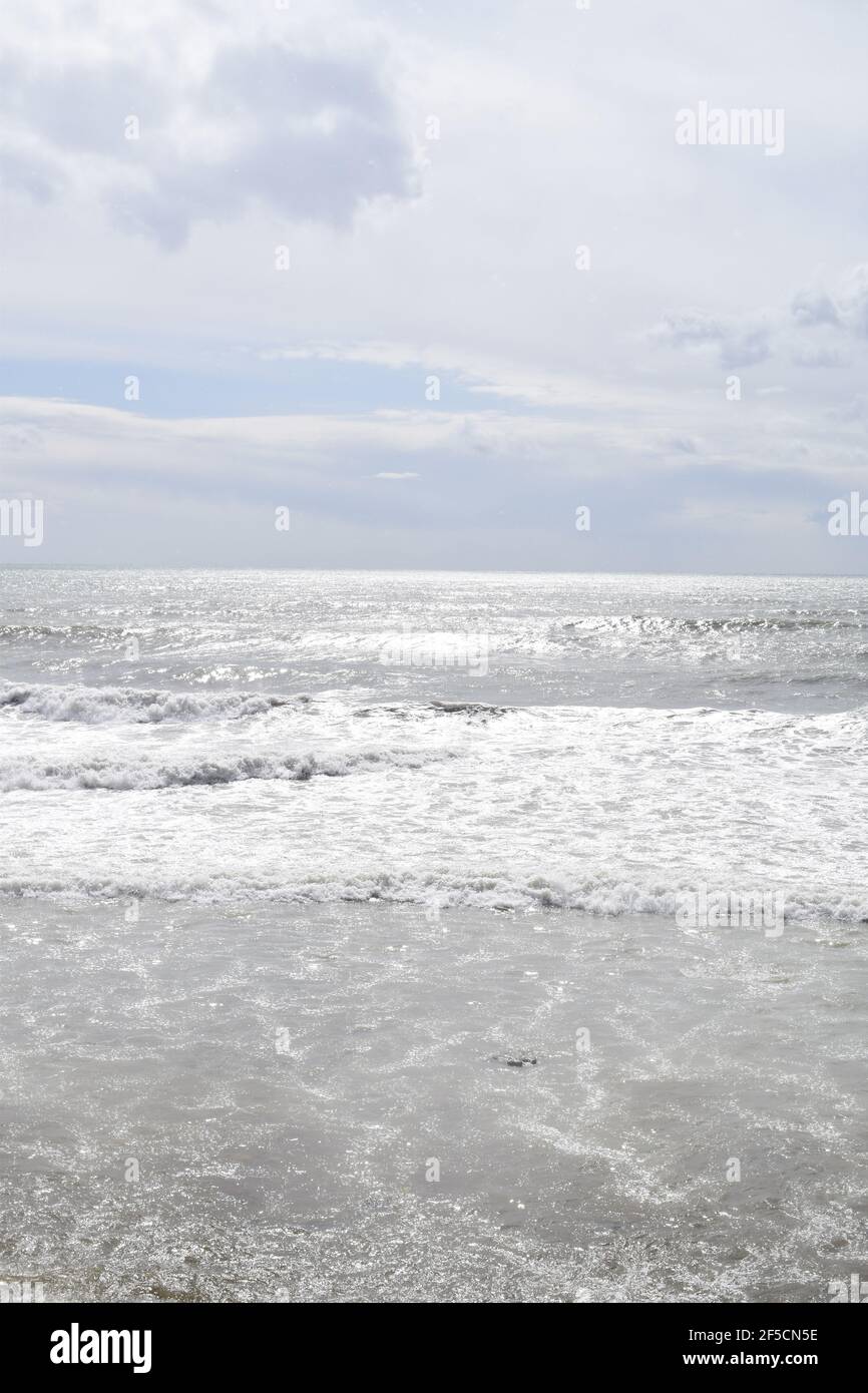 Vertical shot of wavy sea under cloudy sky Stock Photo - Alamy