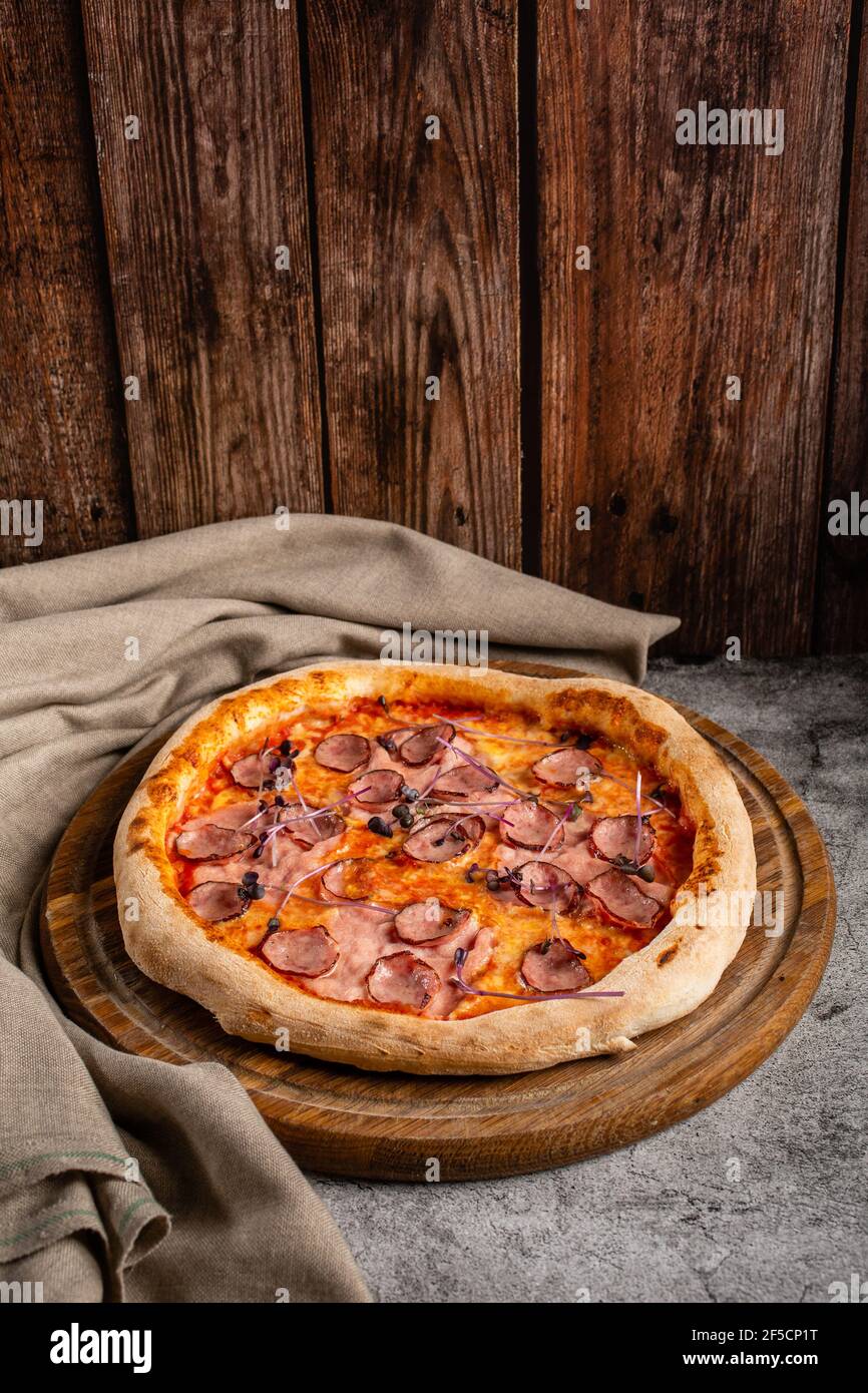 Pizza with meat, cheese and basil. Italian cuisine. Stock Photo