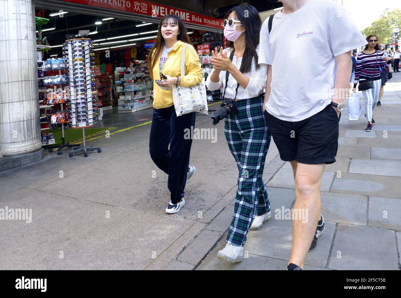 London, England, UK. Asian tourists shopping - one wearing a face mask, during COVID 2020 Stock Photo