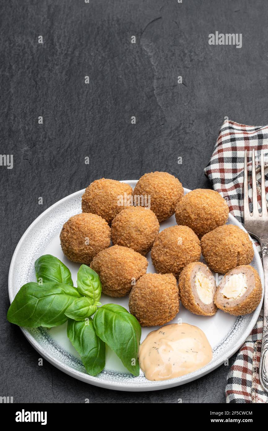 Mini scotch eggs in ceramic plate on black stone background Stock Photo Alamy