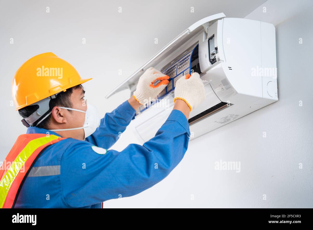 Air conditioner technician wear a safety mask to prevent dust