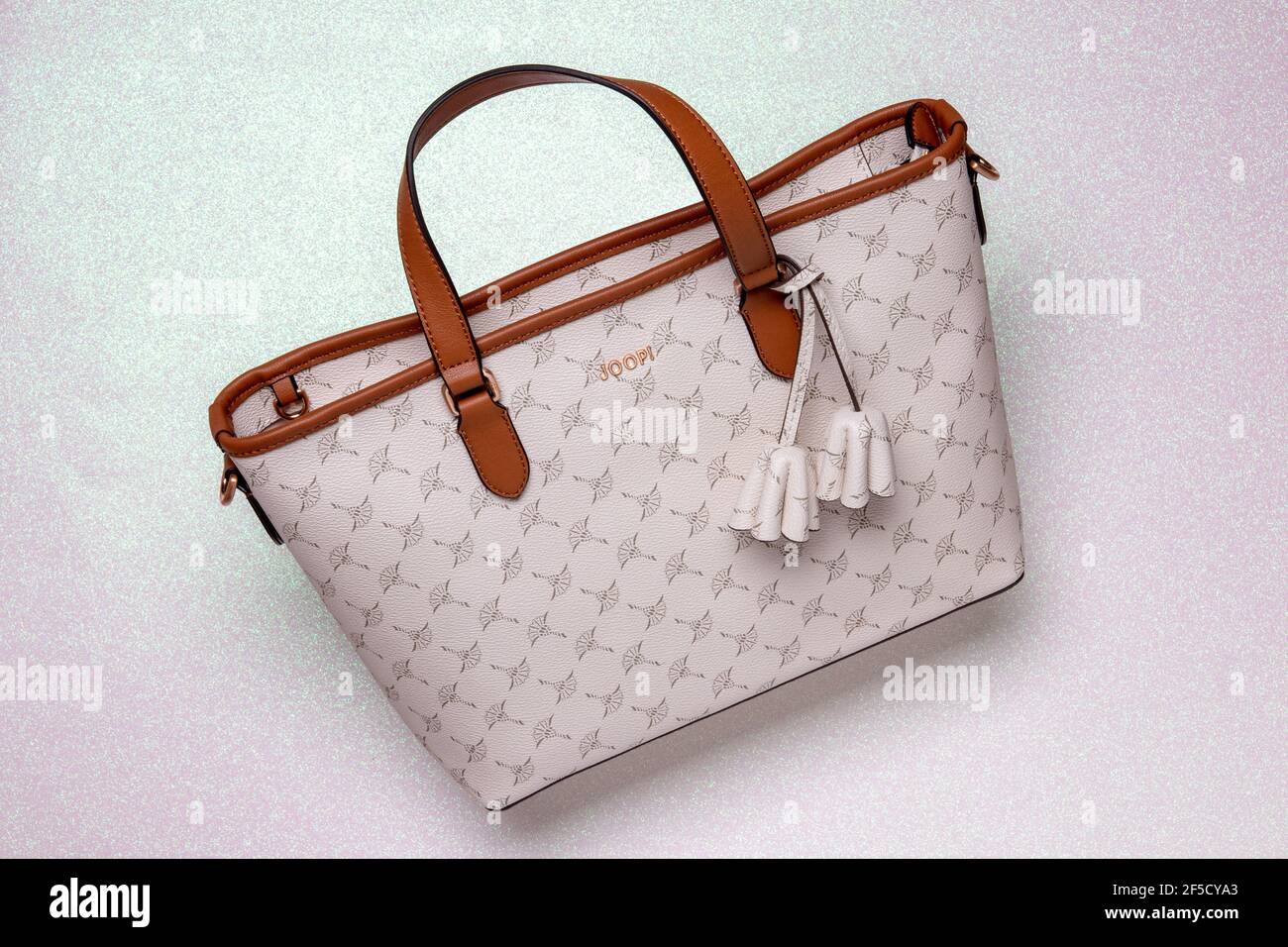 Berlin, Germany – march 19, 2021: Close-up of a luxury light beige Joop leather  handbag in studio lighting on a bright glitter sparkle background. Joo  Stock Photo - Alamy