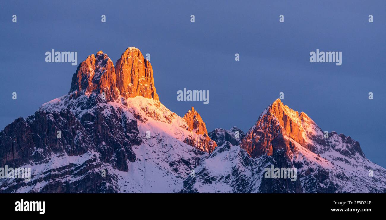 The rising sun casts its first light on the Bischofsmütze mountain in winter and creates a wonderful Alpen glow (Alpenglühen) Stock Photo