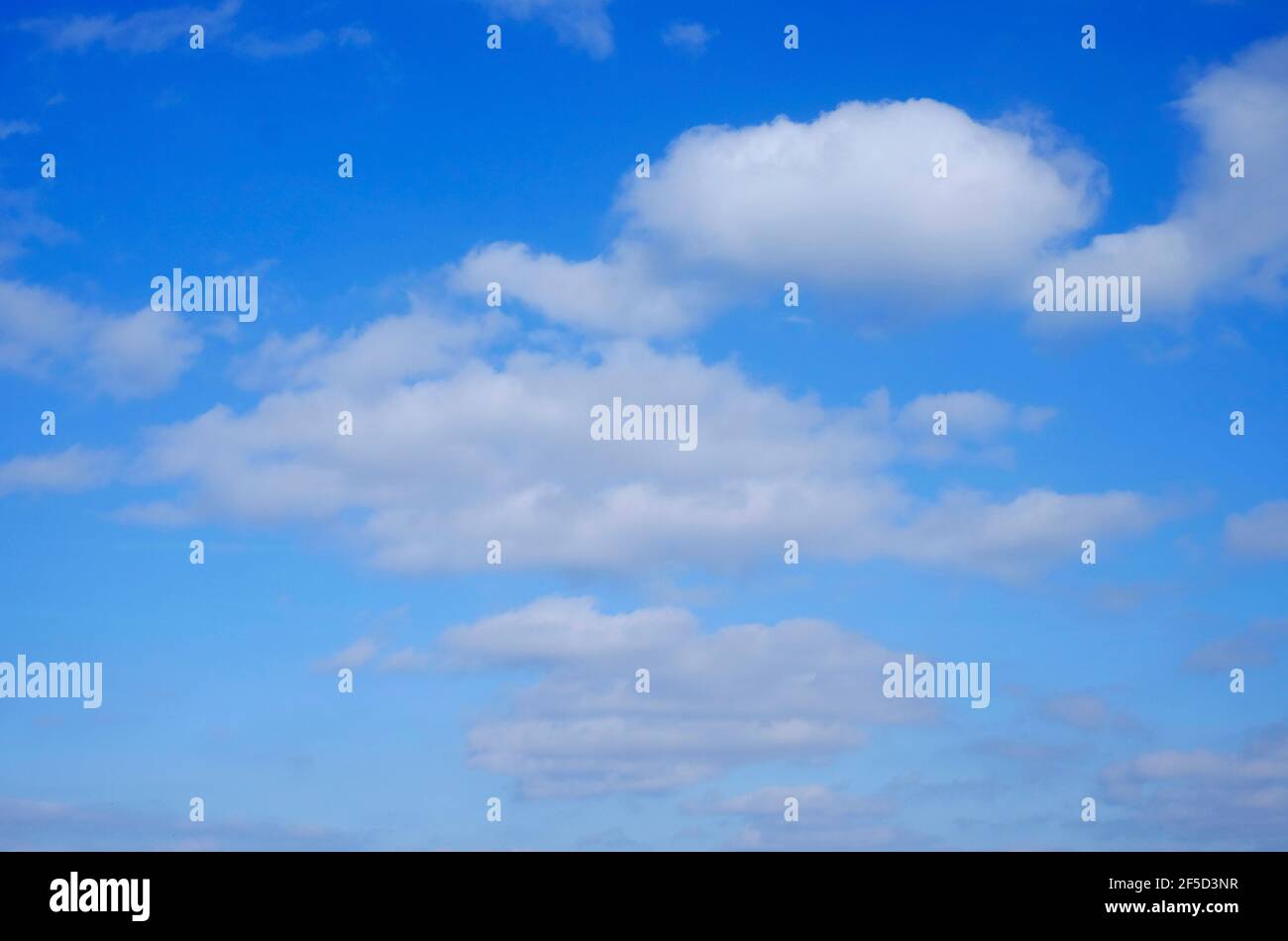 fluffy white clouds on bright blue sky background Stock Photo - Alamy