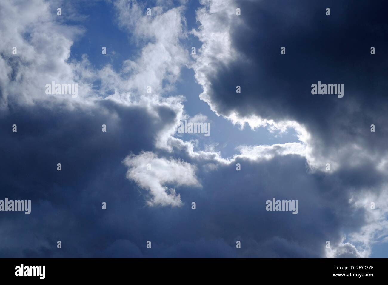 dark storm clouds with backlit sunshine Stock Photo