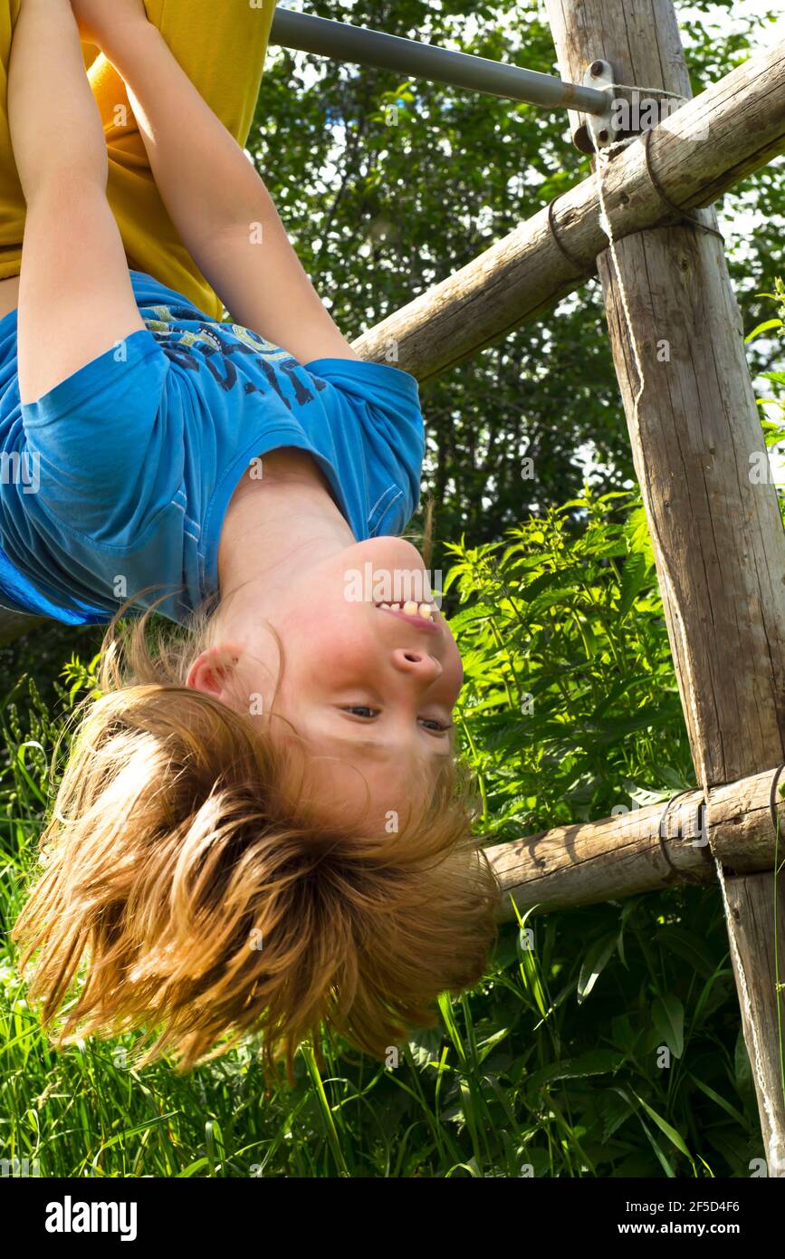 Active child upside down. fun. Laughter. Fooling around in nature. Stock Photo