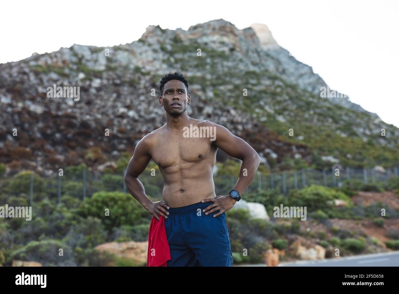 Portrait of fit african american man exercising outdoors on a coastal road Stock Photo