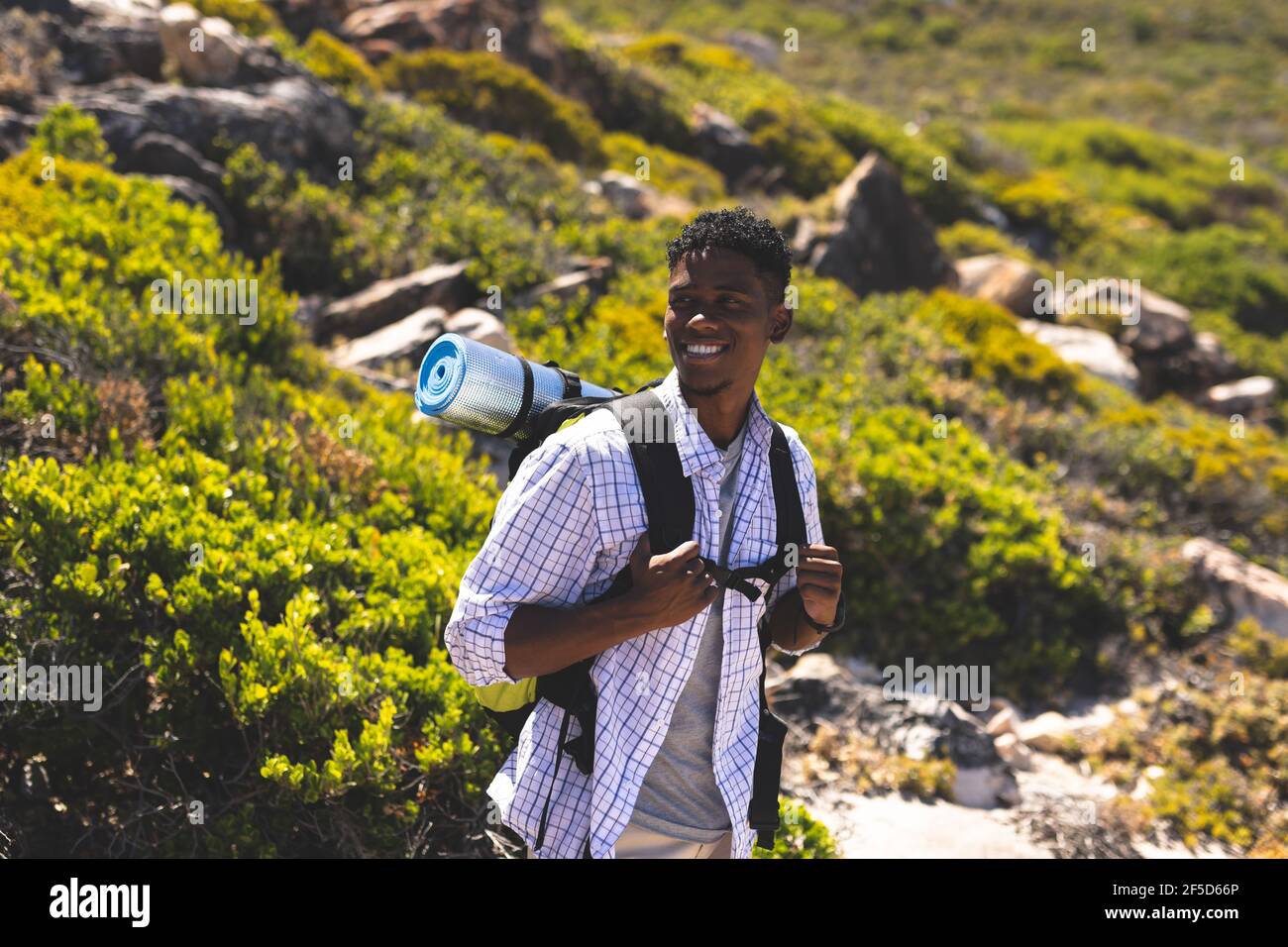 Portrait of fit happy african american man hiking outdoors in ...