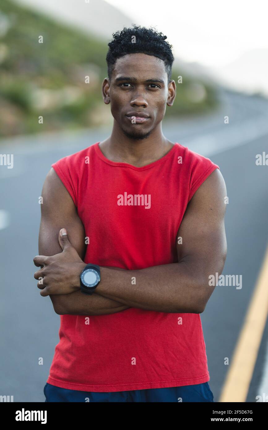 Portrait of fit african american man exercising outdoors on a coastal road to camera Stock Photo