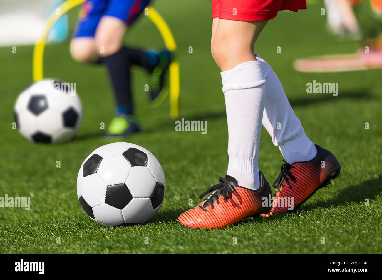 Closeup of child soccer player legs kicking ball. Kid running classic