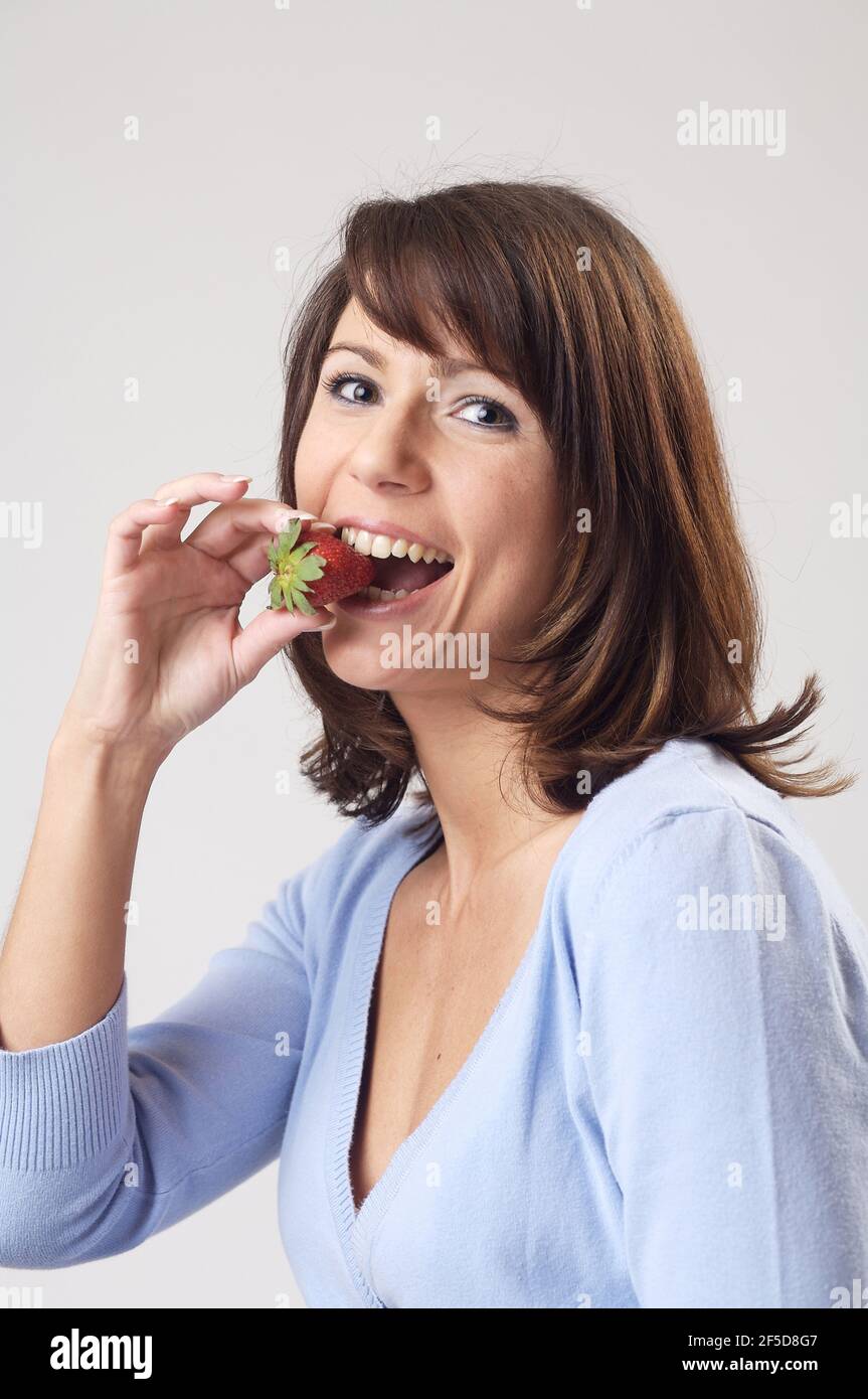, a woman eating a strawberry, Germany Stock Photo