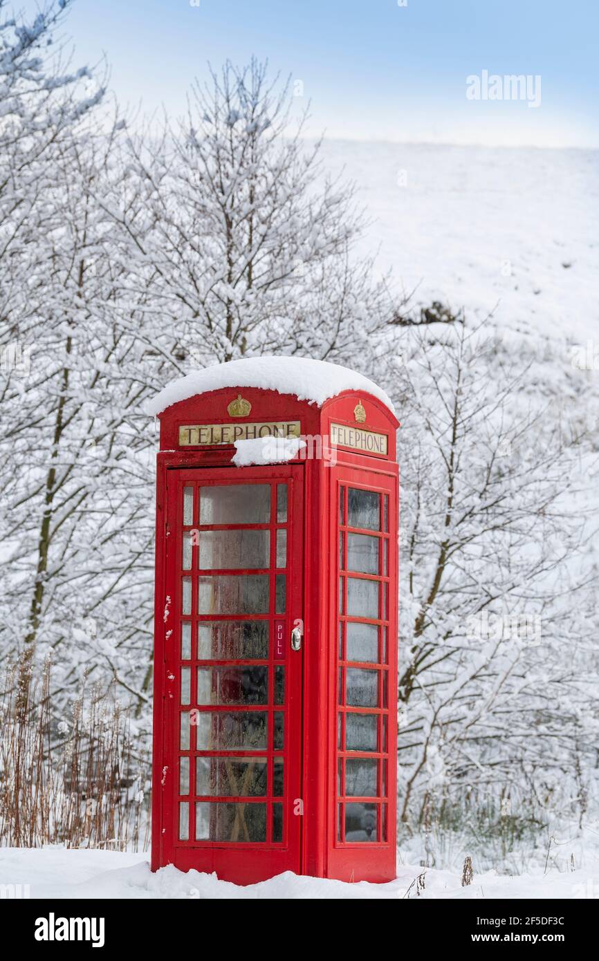Kirkby Stephen, Cumbria, UK, 9th January 2020. A red phone box stands out among the snow in an isolated rural community, Outhgill, in Mallerstang near Stock Photo